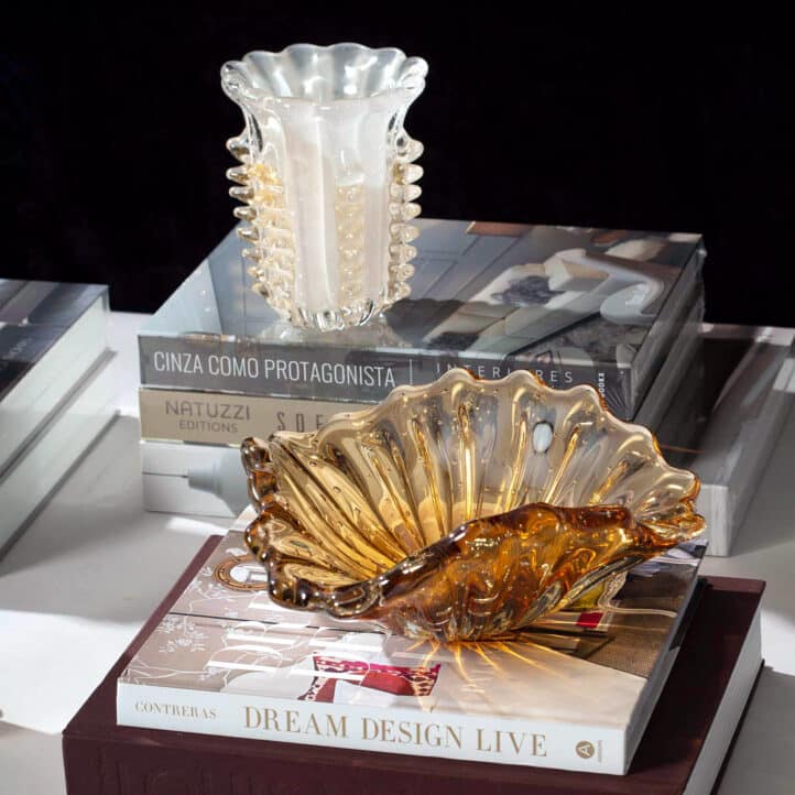 Mês do Cliente com ese belíssimo Centro de Mesa Murano Paris na cor Ambar, numa composição sobre livros e vaso de murano sobre mesa de centro.