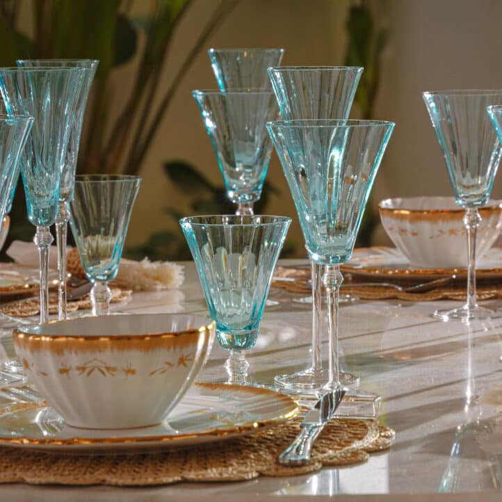 Mes do Cliente: Jogo de 6 Taças de Vinho cor Azul Turquesa, composição mesa posta com jogo de porcelana branca com dourado.