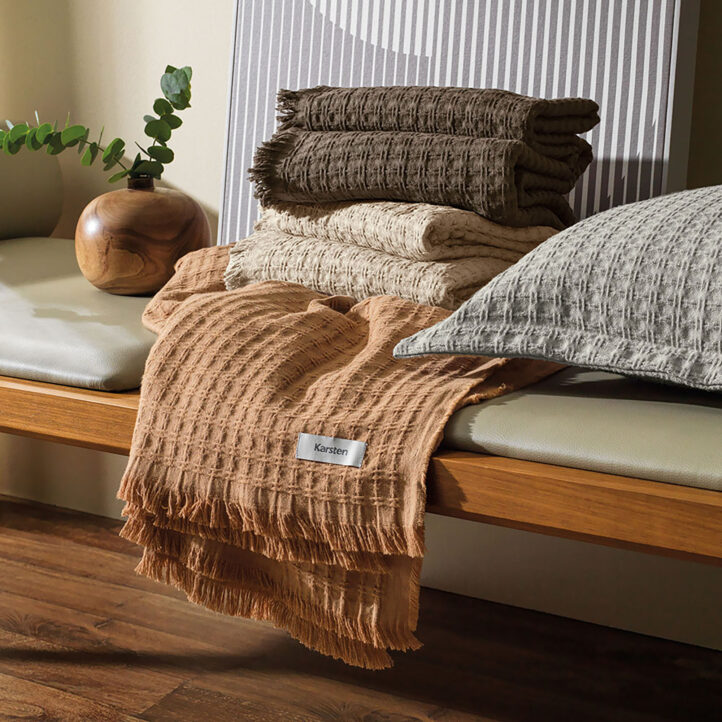 ambiente decorado com mantas e almofadas da marca Karsten