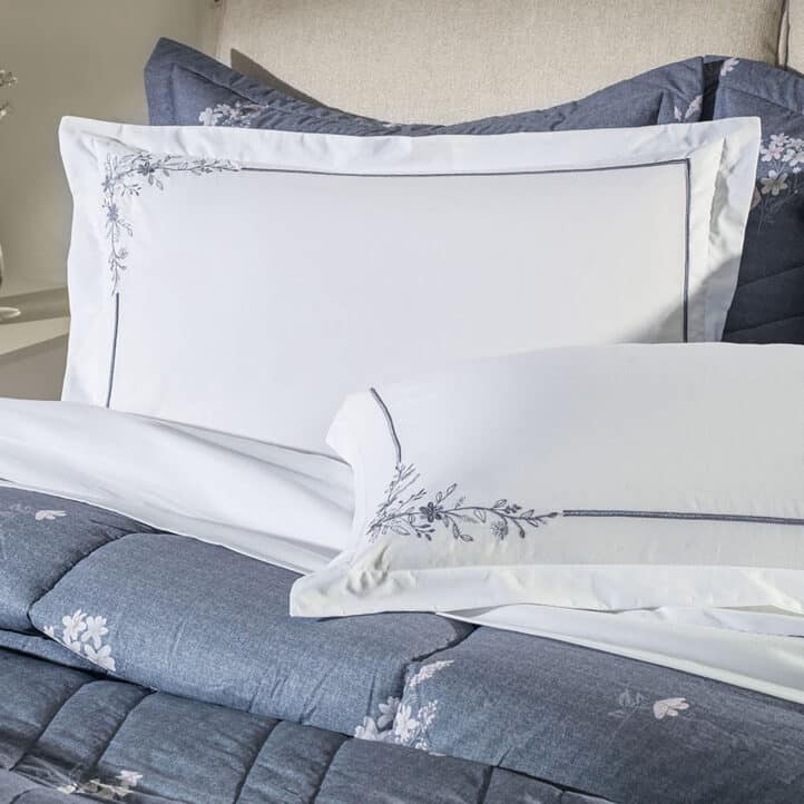 Cama com fronhas brancas e bordadas da Karsten.